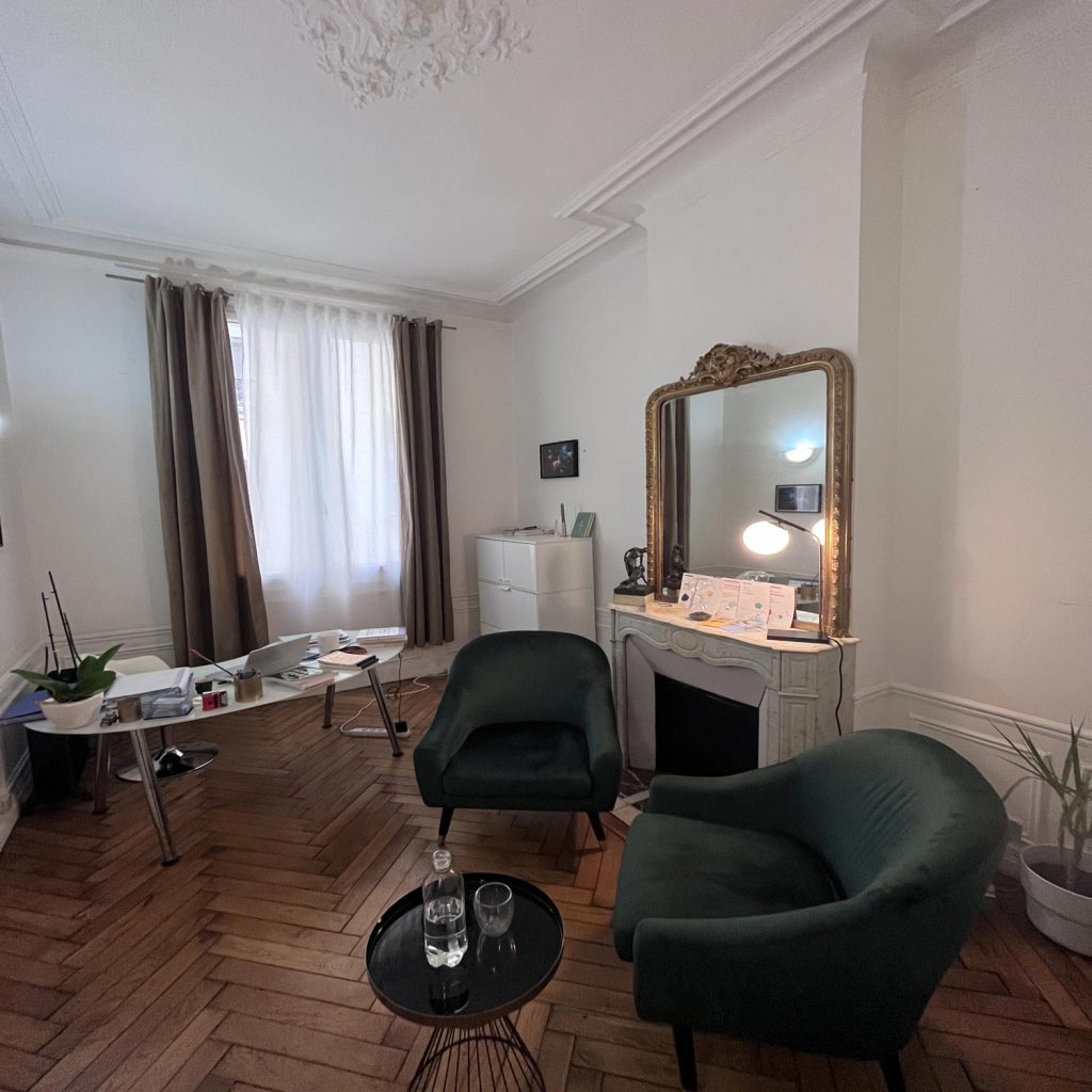 Bureau pour pratique de la thérapie EMDR. Bureau convivial style haussmannien situé dans Paris 16.
Fauteuil bleu canard, parquet chaine, grand miroir et moulures au plafond.